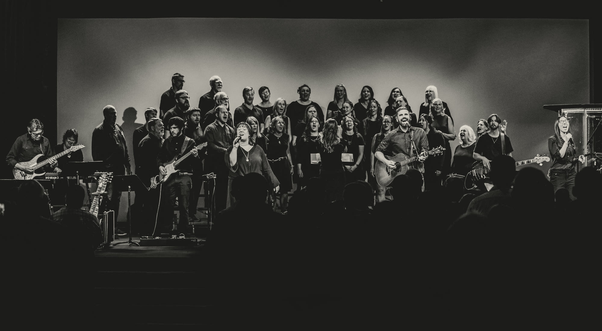 Casey Klocek leading worship with a full band and choir on a Sunday